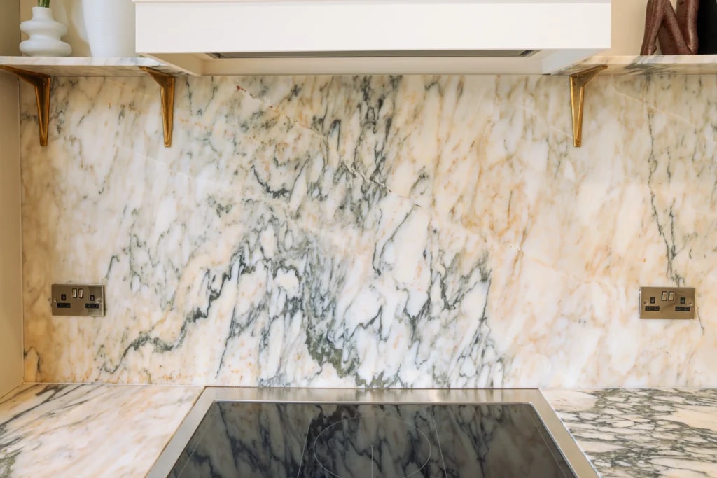 Close-up of Calacatta Monet marble splashback above the hob in a Sussex kitchen