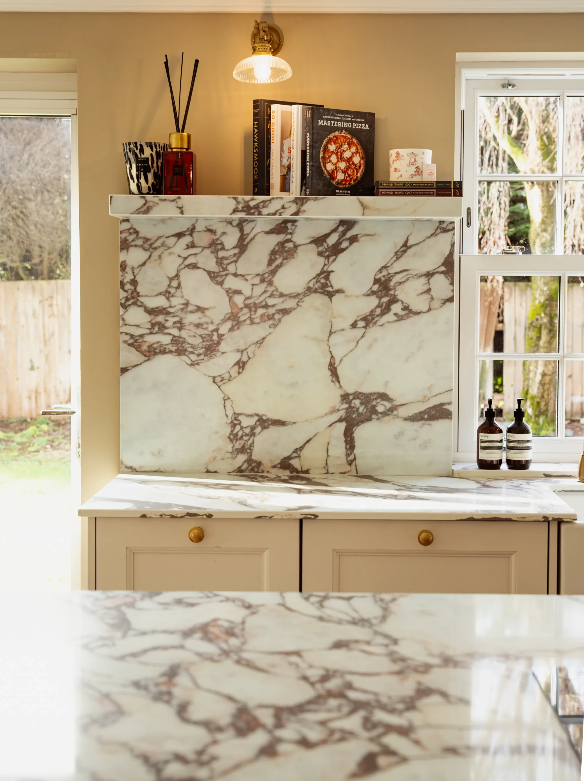 Calacatta Viola worktop showing deep burgundy veining across a warm ivory base
