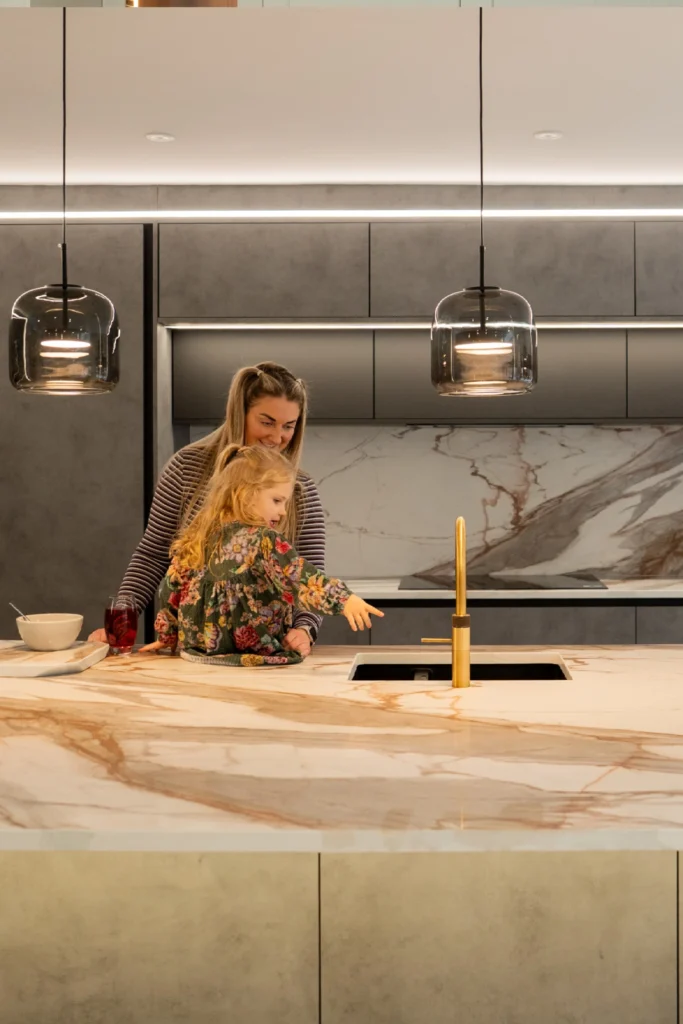 Modern kitchen with ELORĀ stone island and soft pendant lighting