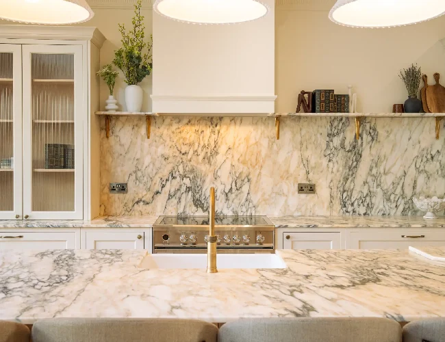 Classic kitchen featuring natural stone worktops and splashback