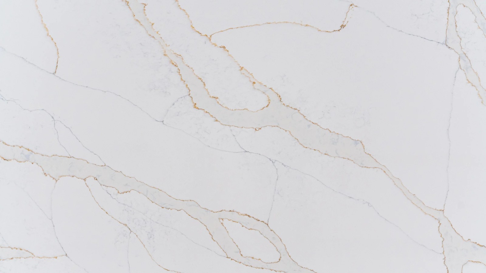 Calacatta Gold engineered stone surface close-up showing flowing grey veins and subtle gold details