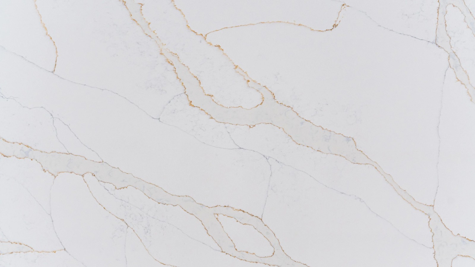 Calacatta Gold engineered stone surface close-up showing flowing grey veins and subtle gold details