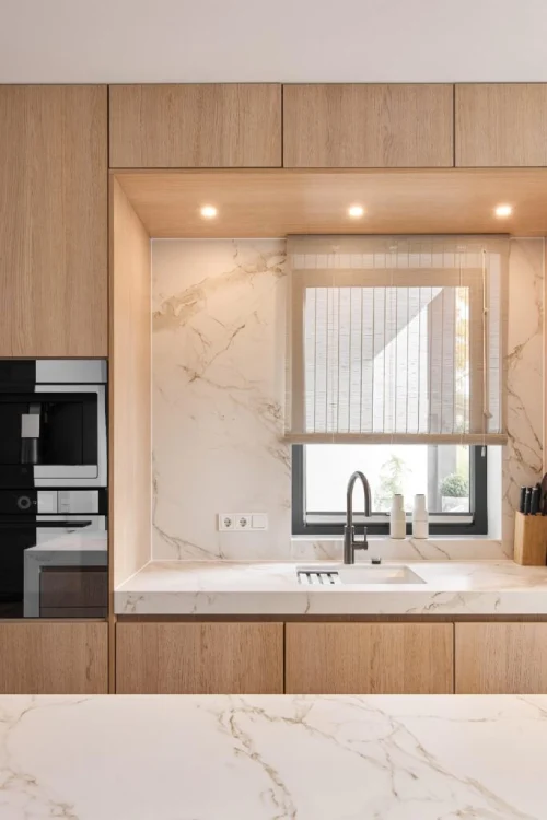 Bright contemporary kitchen featuring DEKTON marble-effect worktops with light oak cabinetry