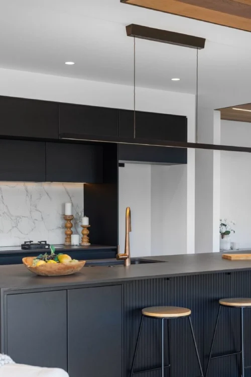 Modern kitchen with dark blue cabinetry and DEKTON waterfall island worktop