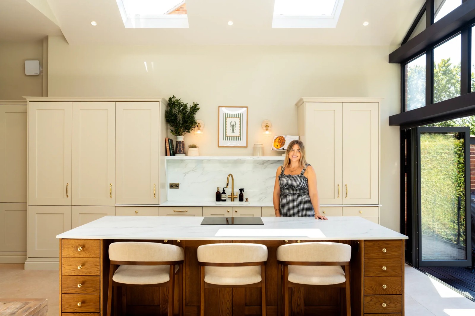 Calacatta Oro quartz worktops in a modern kitchen with cream cabinets and a wooden island
