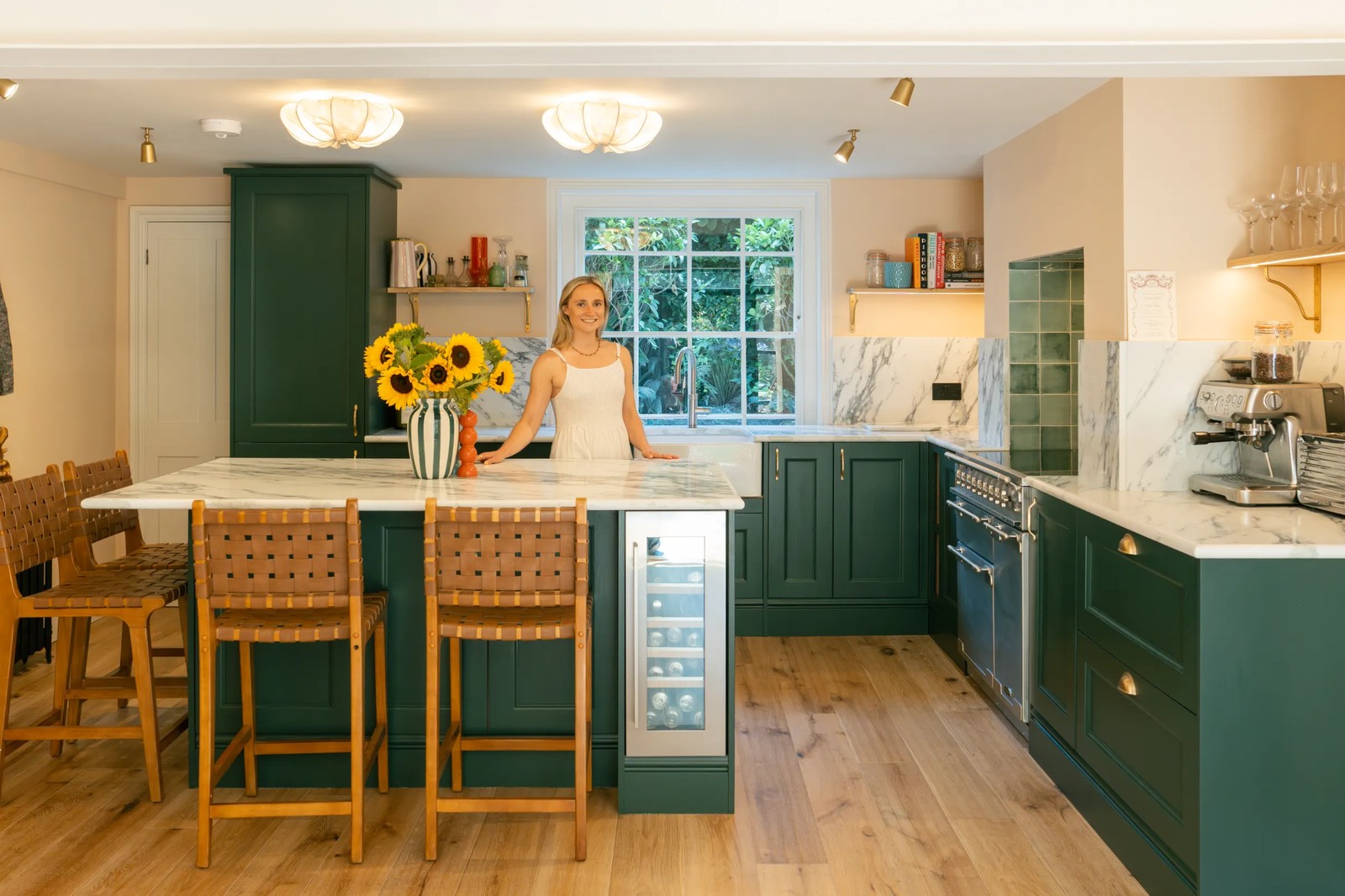Calacatta Verde worktops and matching splashback in a kitchen with dark green cabinets and a wooden island in Hackney