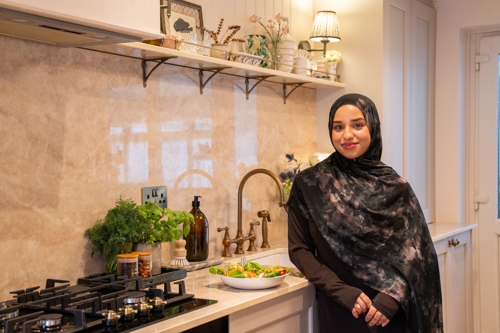 Maj standing beside her finished kitchen featuring SINTERRA Crema worktops