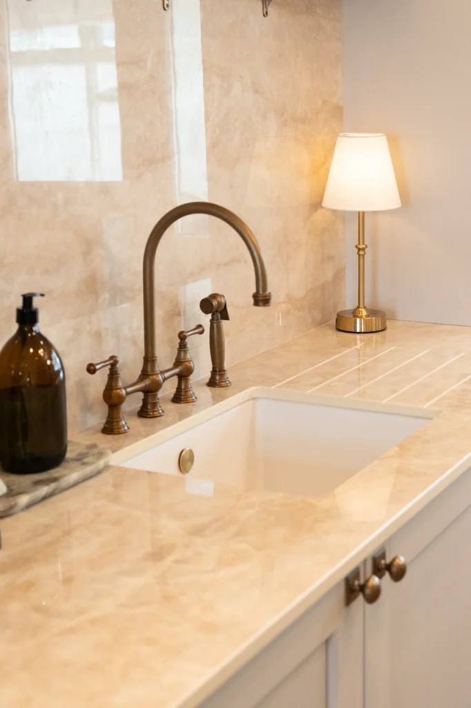 SINTERRA Crema worktop around the kitchen sink with brass taps