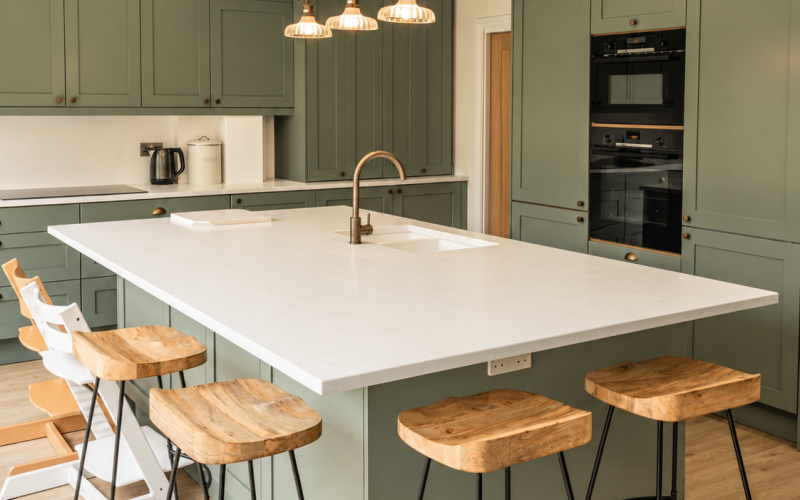 Bianco Carrara white worktops paired with sage green kitchen cabinets.