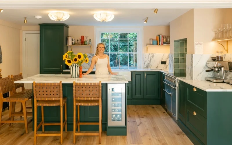 Calacatta Verde worktops and matching splashback in a kitchen with dark green cabinets and a wooden island in Hackney