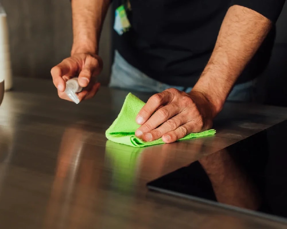 man cleaning kitchen worktop